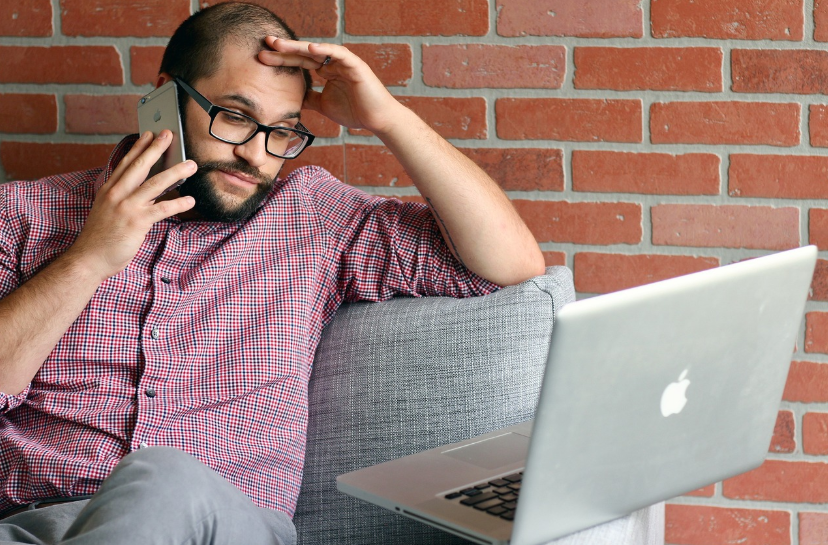 Google Penalty: How Your Small Business Can Recover 1 Frustrated man in glasses on phone call with laptop